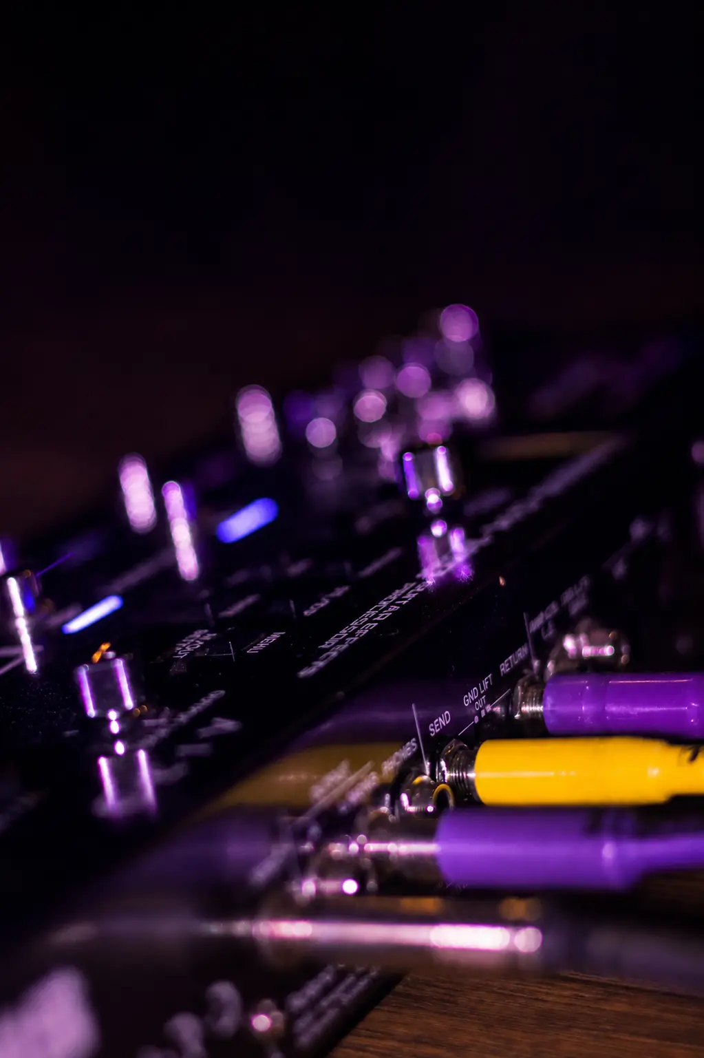 Detalhe de pedais e guitarra no palco