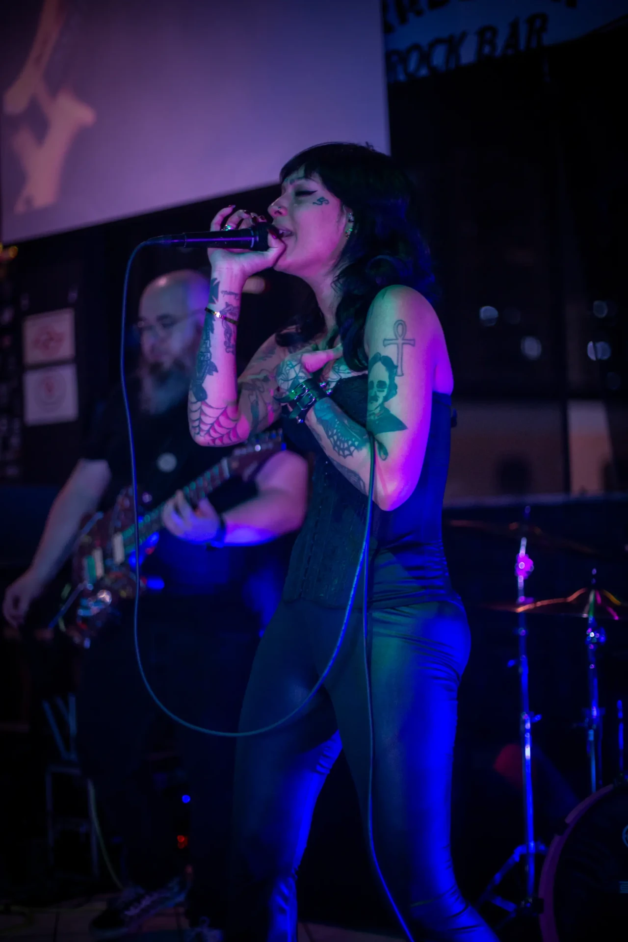 Vocalista de perfil cantando no palco
